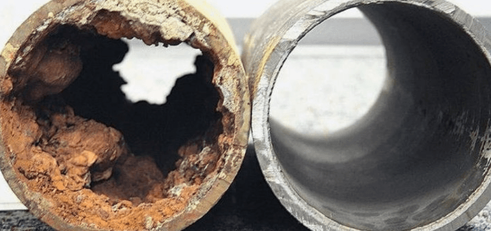 Side-by-side comparison of a corroded, restricted drain pipe and a clear, healthy pipe